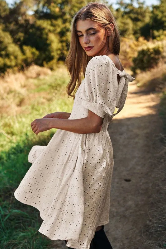 Trendsi romantic eyelet baby doll dress in light color with puff sleeves and tie-back detail