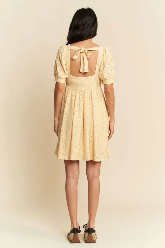Trendsi romantic eyelet baby doll dress featuring puff sleeves and a tying back detail in soft yellow