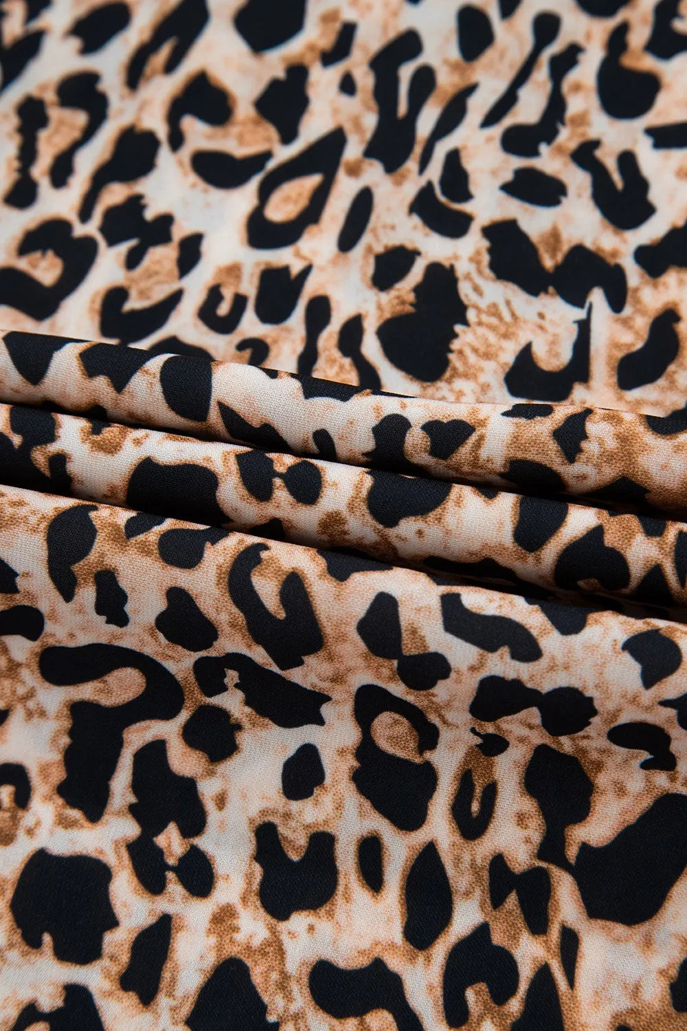 Stylish leopard print top featuring a soft fabric with a trendy animal pattern in black and brown