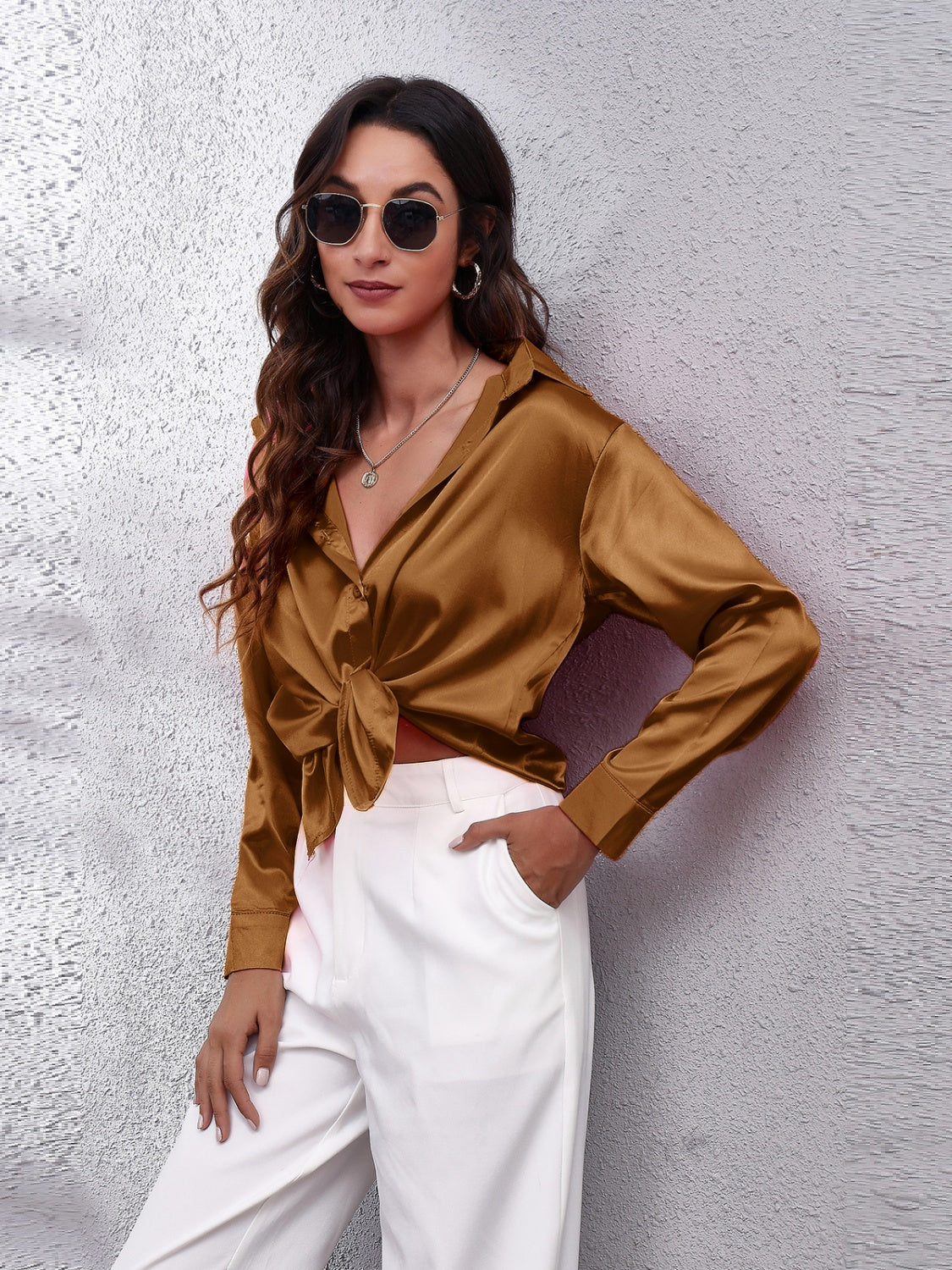 Trendy woman in a brown affordable long sleeve shirt styled with white pants and sunglasses