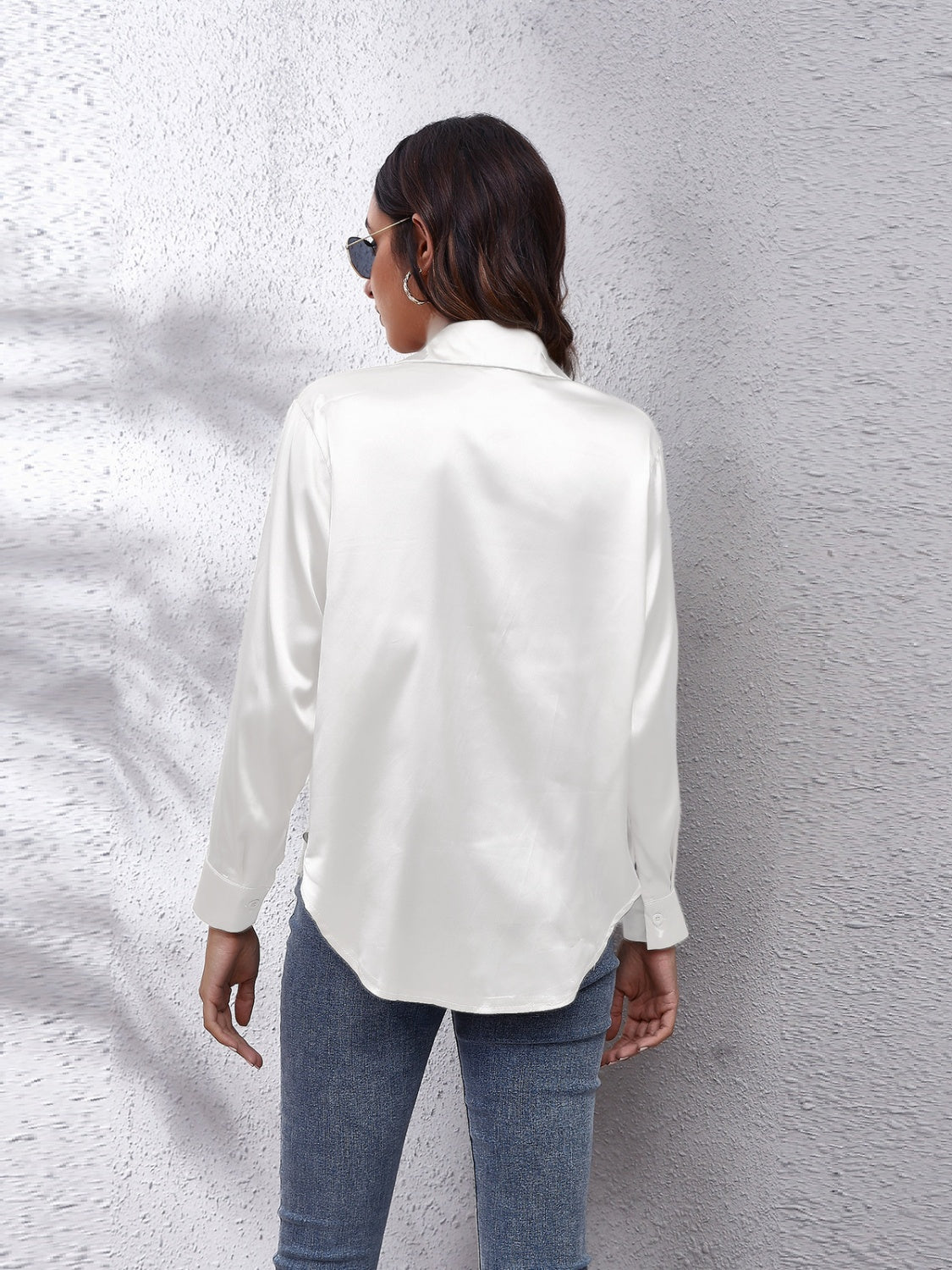 Back view of a stylish white affordable long sleeve shirt paired with jeans and sunglasses