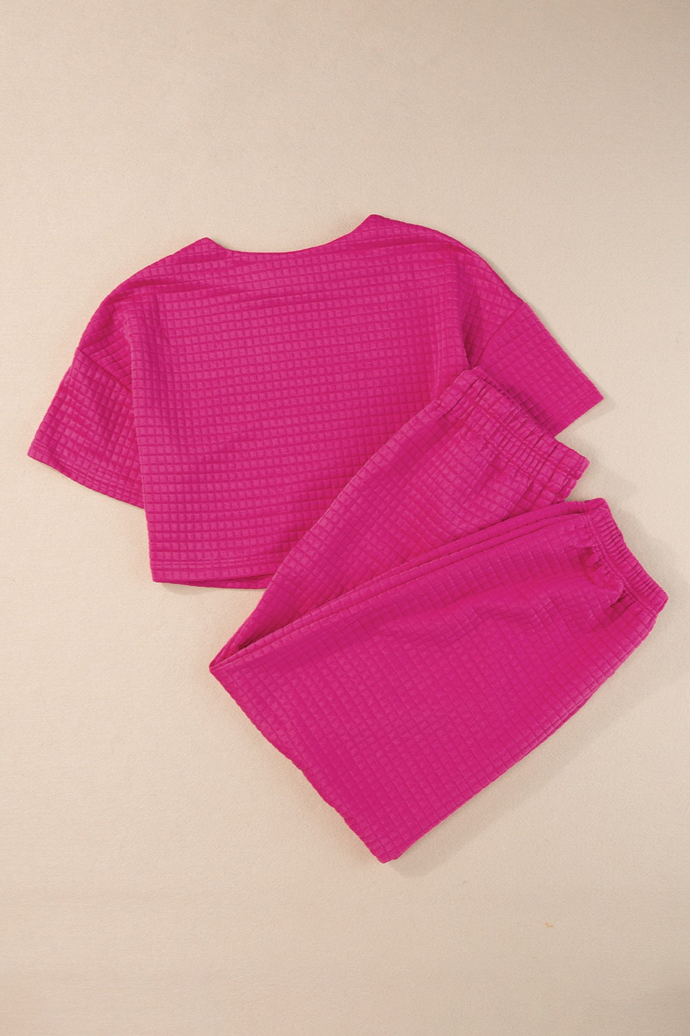 Trendy pink casual summer outfit featuring a matching top and shorts in a textured fabric