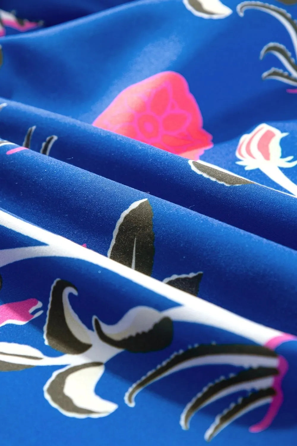 Close-up of the fabric detailing on a women's high waist summer dress featuring vibrant floral patterns